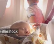 Baby girl is falling asleep on mothers lap after breastfeeding. Comfortable plane journey with mom and elder brother who looking out illuminatornLicense this clip: https://fillerstock.com/video/13038
