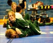 Two young women team mates on a high school wrestling team practice before a meet. The girls are friends but the competitive nature of both female athletes is evident.