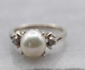 Simple and classic, this classic pearl ring has a beautifully polished white 14-karat gold band, and two small accent diamonds set on each side of the cultured pearl. The band has a simple and fluid design, and the creamy white cultured pearl with grey undertones and makes the perfect understated piece.nnnMetal: 14K White GoldnGem: Pearl, 0.52gnGem Measurements: 7.1 mm, roundnAccents: 2 diamonds totaling 0.05 carats, SI2 in clarity, H in colornRing Size: 4.5nMarks: