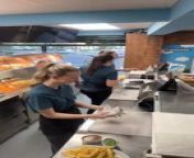 These girls were preparing meals at the restaurant. One of the girls accidentally spilled sauce near the food and later removed the sheet containing the spilled sauce. Another girl made the same mistake twice, and they burst out laughing.
