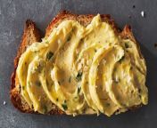 Minced garlic, softened butter, lemon zest, and parsley are whipped into a smooth spread in this easy, homemade garlic butter recipe.