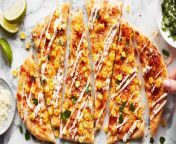 This Mexican Street Corn Flatbread is slathered with tangy sour cream sauce, loaded with corn and cheese, and baked to crispy perfection.